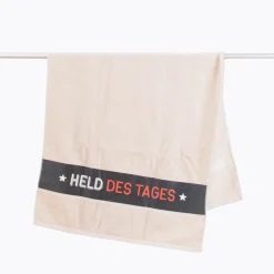 Badetuch aus Baumwolle Held des Tages beige schwarz weiß orange 70x140cm von La Vida